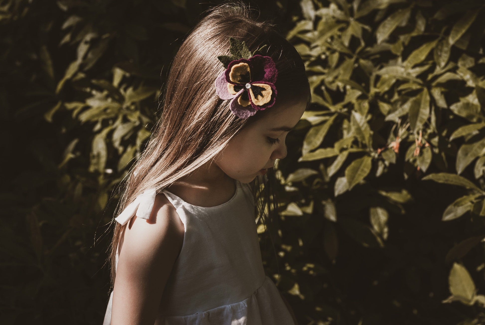 girl stood in garden in summer wearing a cotton linen dress in white adjustable straps sustainable bohemian hippy beach clothing